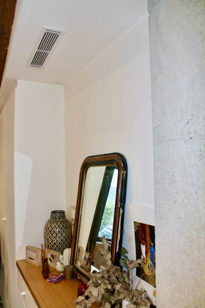 Grille de soufflage d'une pompe à chaleur air air Toshiba dans un salon d'appartement à Lyon